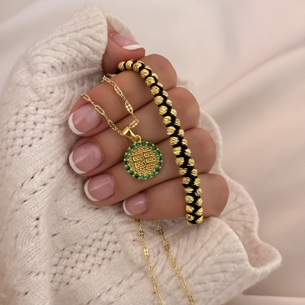 Cadena Fe con pulsera dorada puesta en la mano