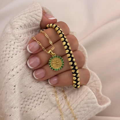 Cadena Fe con pulsera dorada puesta en la mano